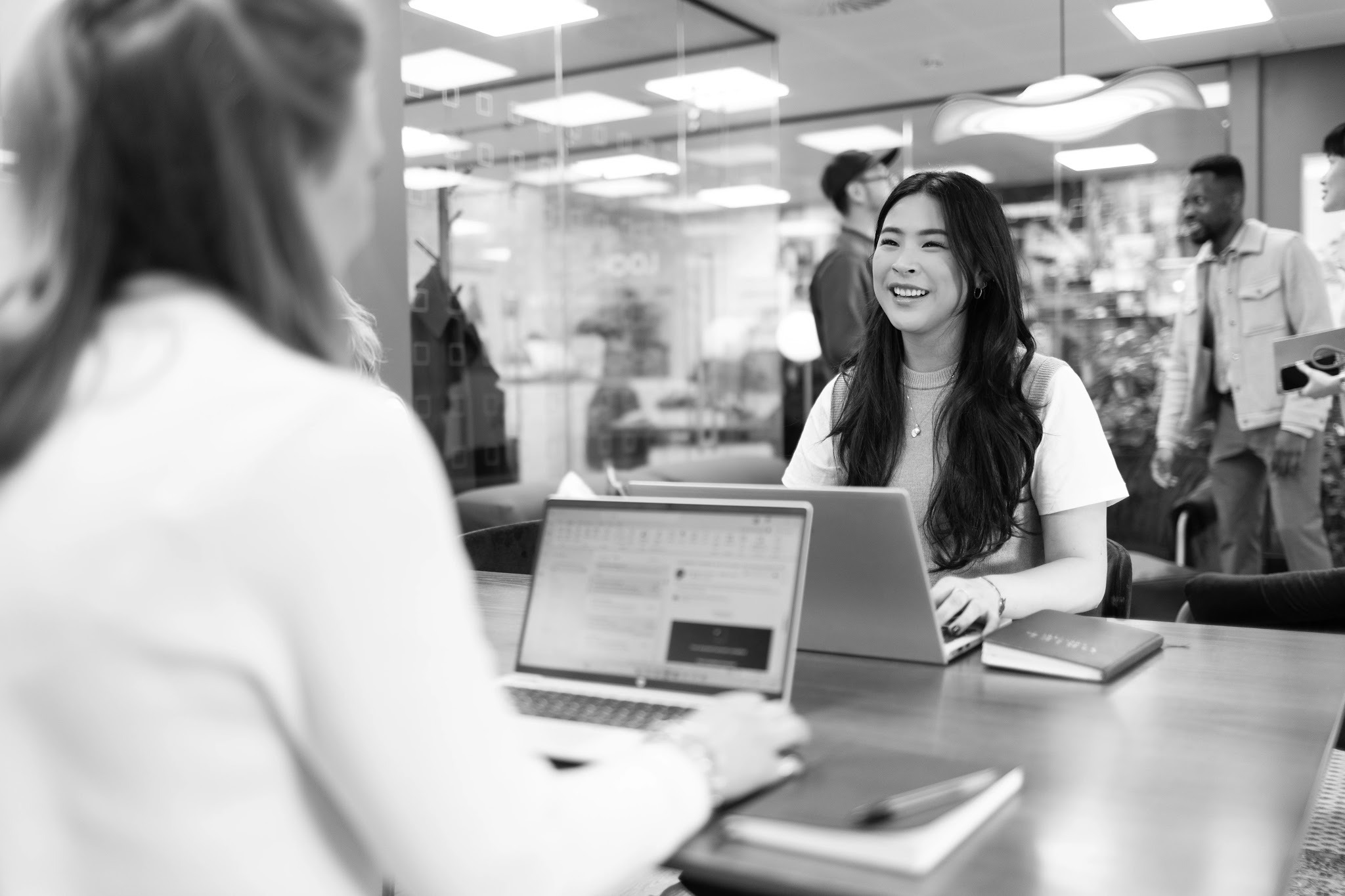 Recruitment consultant and candidate in conversation at a temp agency, both working on laptops