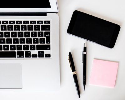 Desk with laptop, pens and phone