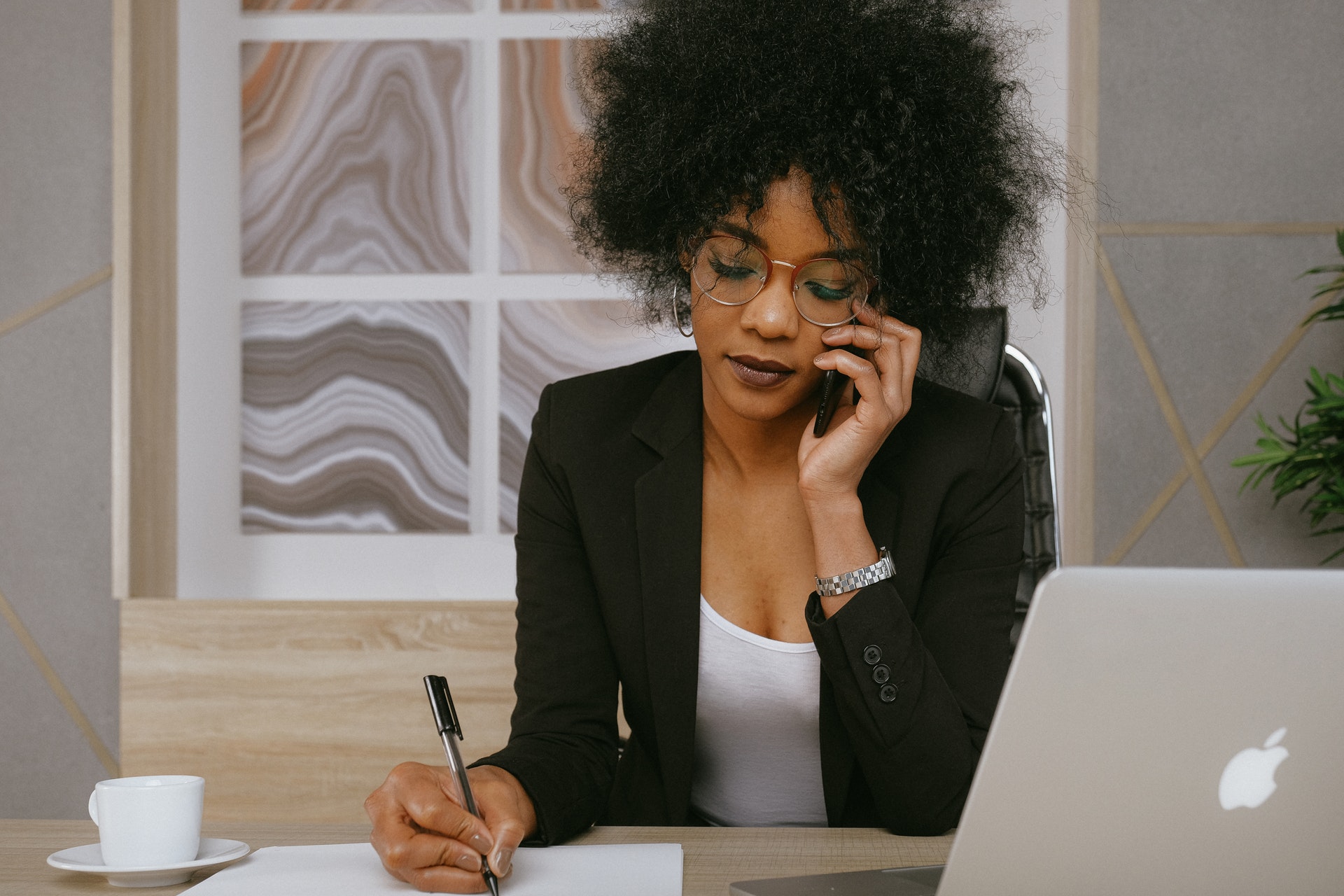 Receptionist taking notes while on the phone