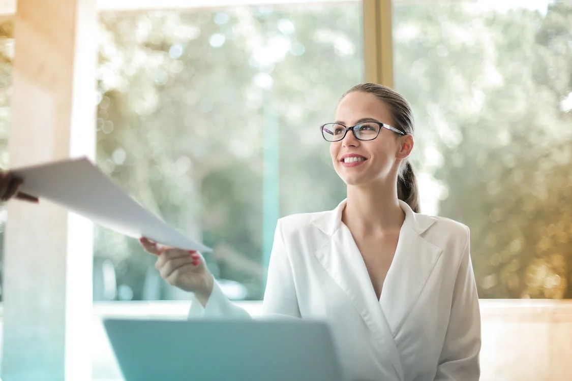 Two women in a meeting room discussing business documents