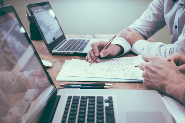 two people sit at laptops managing finance for a family office using family office software