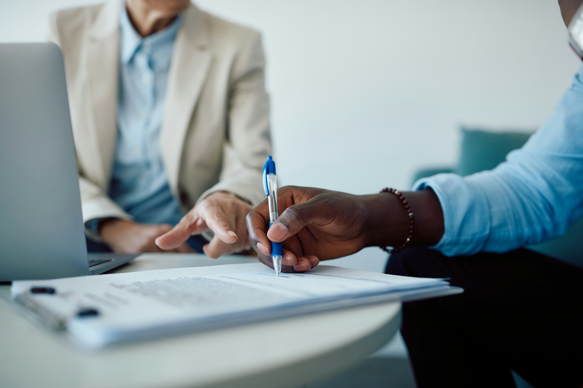 A man signs a fixed term contract in front of his new employer.