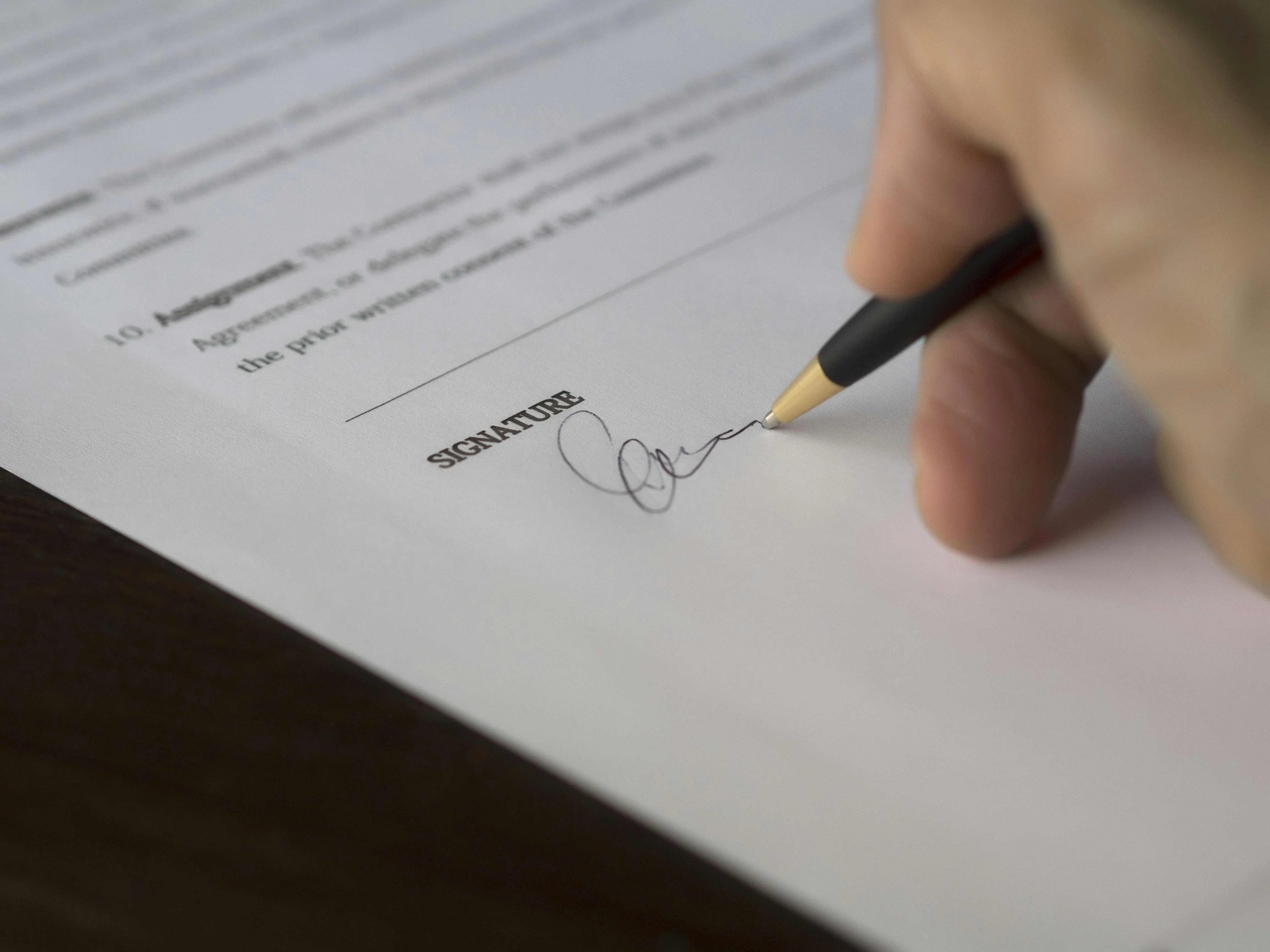 A person signing a temporary employment contract.